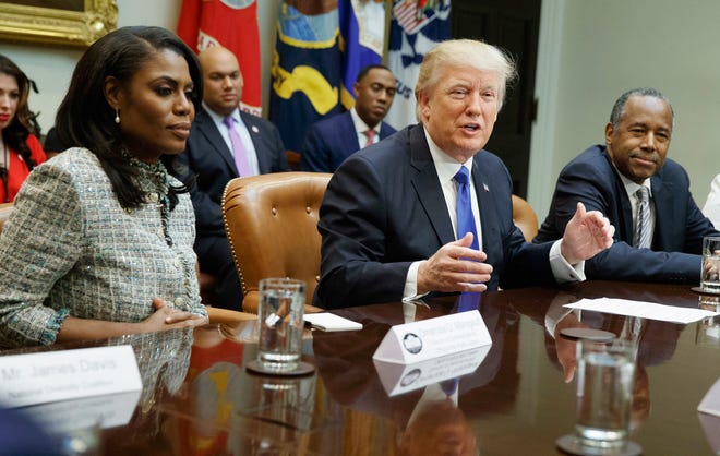 FILE - In this Feb. 1, 2017, file photo, President Donald Trump, center, is flanked by White House staffer Omarosa Manigault Newman, left, and then-Housing and Urban Development Secretary-designate Ben Carson as he speaks during a meeting on African American History Month in the Roosevelt Room of the White House in Washington.