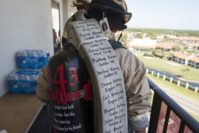 During the September 2017 stair climb at Edgewater Beach & Golf Resort, Zack Barrett, a firefighter from Hattiesburg, Miss., carries a fire hose with the names of all firefighters who died responding to the 9/11 terrorist attacks. [JOSHUA BOUCHER/NEWS HERALD FILE]