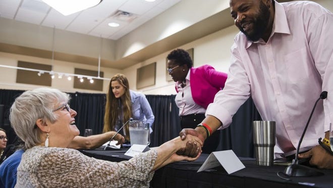Candidate Lewis Conway Jr., right, chats with his childhood neighbor Carol Eckelkamp, left, following the 2018 District 1 Candidate Forum at the Asian American Resource Center on Thursday. Fellow candidates Natasha Harper-Madison, middle, and Mitrah Avini, middle left, greet attendants at the rear. AMANDA VOISARD / AMERICAN-STATESMAN