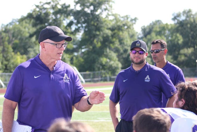 Deerfield graduate and former Britton Deerfield football player Dustin Beurer, right front, has been named the next head football coach for the Albion College Britons. Beurer will replace the current coach Craig Rundle, left, who will retire at the end of the season.