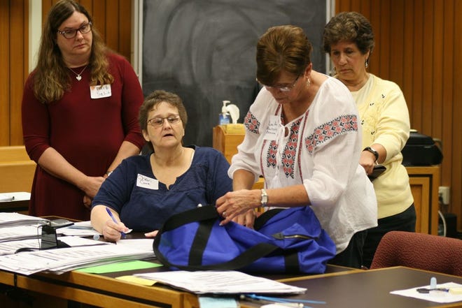 Woodstock Township Clerk Chari Cure, left, and retired Lenawee County Clerk Lou Ann Bluntschly-Brazee, second from right, inspect the bag containing a provisional ballot cast in Tecumseh in the Lenawee County probate judge primary election during the second recount of the votes in Tecumseh's Precinct 4 Thursday in Lenawee County Circuit Court. Standing at left is Barb Sala, an observer for candidate Catherine Sala, and Grace Garno, an observer for candidate Kristi Drake.