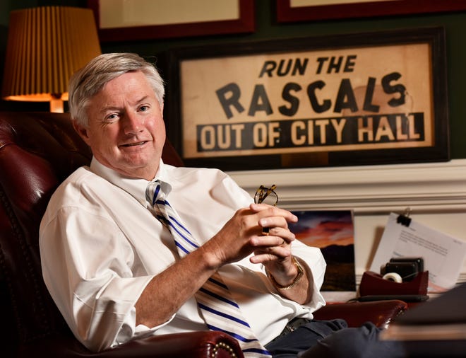 State Farm insurance agent and former city councilman Matt Carlucci, photographed in his office with a "Run the Rascals Out of City Hall" sign that he helped make when he was a boy. It was designed and printed by his older brother Michael Carlucci for their father, Joe Carlucci, for the campaign to consolidate the city in 1968. Joe Carlucci was on the first City Council after consolidation. [Will Dickey/Florida Times-Union]