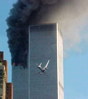 In this Sept. 11, 2001 file photo, United Airlines Flight 175 approaches the south tower of the World Trade Center in New York shortly before collision as smoke billows from the north tower.