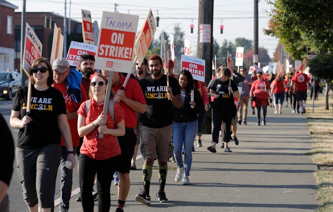 Striking Tacoma Teachers walk a picket line, Thursday, Sept. 6, 2018, in front of Lincoln High School in Tacoma, Wash. Fights over teacher salaries and work conditions are escalating along the West Coast, and the disputes are particularly acute in Washington, a state that has infused at least $1 billion for teacher pay to resolve a long-running court battle. (AP Photo/Ted S. Warren)