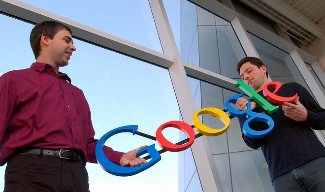 FILE- In this Jan. 15, 2004, file photo Google co-founders Larry Page, left, and Sergey Brin pose for a photo at their company's headquarters in Mountain View, Calif. Twenty years after Page and Brin set out to organize all of the internet’s information, the search engine they named Google has morphed into a dominating force in smartphones, online video, email, maps and much more. (AP Photo/Ben Margot, File)