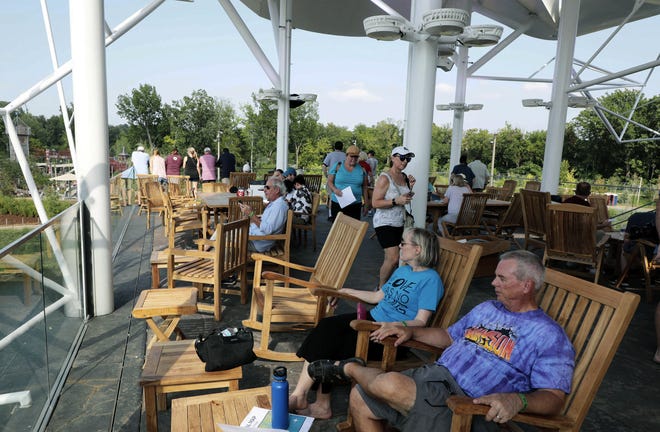 In this Aug. 26, 2018 photo, people enjoy the view at the ONEOK Boathouse at the Gathering Place in Tulsa, Okla. The public park, the first phase of what will be one of the biggest parks in the U.S., is set to open Saturday, Sept. 8, It has been built with private money led by billionaire philanthropist George Kaiser. (Tom Gilbert/Tulsa World via AP)
