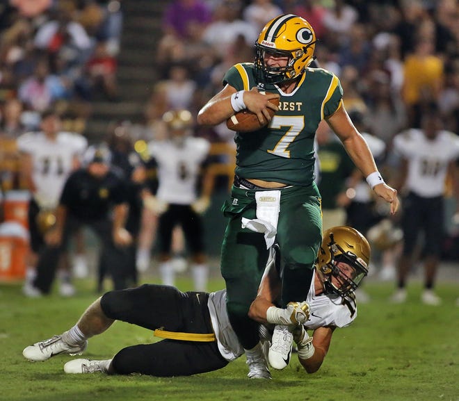 Nick Stites attempts to bring down Crest quarterback Peyton Kimmerlin at Crest High School on Friday. [Brittany Randolph/The Star]