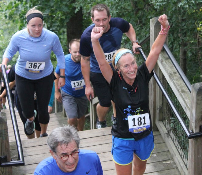 Shannon Corrigan (right), of Middleville, raises her hands as she reaches the top of Mt. Baldhead. Robert Parks of Kalamazoo (No. 284) and Kristy Zimmer of Grandville (No. 367) trail her along with Tim Nelson of Holland (No. 137). [Chris Zadorozny/Sentinel staff]
