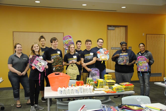 A group of Mount Wachusett Community College Leadership Academy students hold backpacks they have filled with supplies for children in foster care. Also in the photo are MWCC’s Assistant Dean for K-12 Partnerships and Civic Engagement Fagan Forhan and MWCC Associate Professor of Sociology and Human Services Candace Shivers. [SUBMITTED PHOTO]