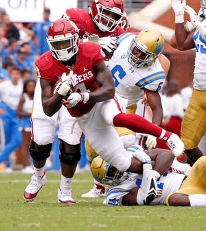 Oklahoma's Trey Sermon (4) leaps over UCLA's Krys Barnes (14) during a college football game between the University of Oklahoma Sooners (OU) and the UCLA Bruins at Gaylord Family-Oklahoma Memorial Stadium in Norman, Okla., on Saturday, Sept. 8, 2018. Photo by Steve Sisney, The Oklahoman