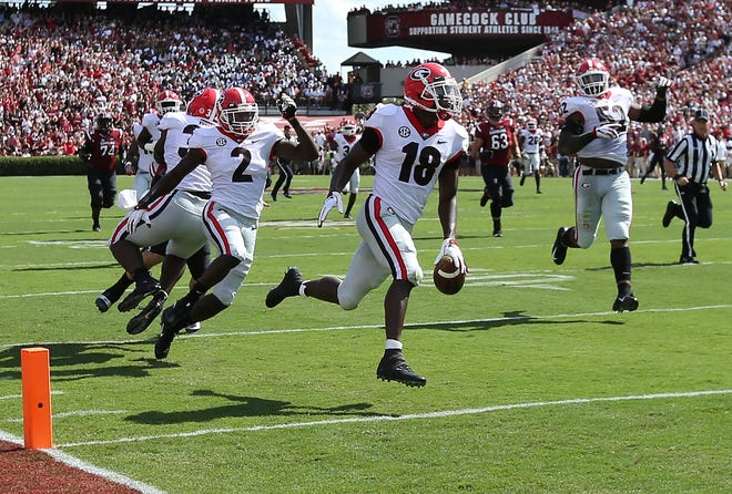 Georgia defensive back Deandre Baker returns an interception for a touchdown during the first quarter against South Carolina on Saturday in Columbia, S.C. [Curtis Compton/Atlanta Journal-Constitution]