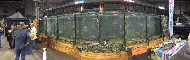 "What's in Outdoors" radio show host Phil Taunton, left, stands in front of a giant fish tank filled with several species of Kansas sportfish provided by the Kansas Department of Wildlife, Parks and Tourism during the 2017 Topeka Boat and Outdoor Show at the Kansas Expocentre. [2017 file photograph/The Associated Press]