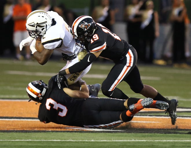 Massillon's Dean Clark (19), along with Preston Hodges, tackles Warren Harding's Kay'Ron Adams during Friday's game.

(IndeOnline.com / Kevin Whitlock)
