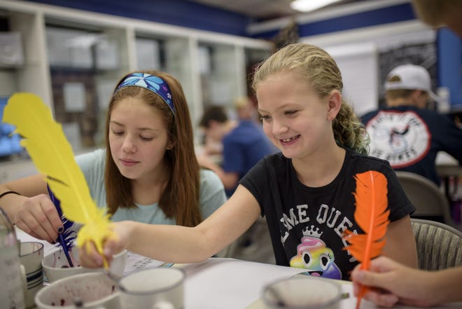 Emilia Schweitzer, left, and Danielle Falls write with homemade quills during a summer day camp devoted to cursive instruction in Danbury, Connecticut. [MONICA JORGE FOR THE WASHINGTON POST]