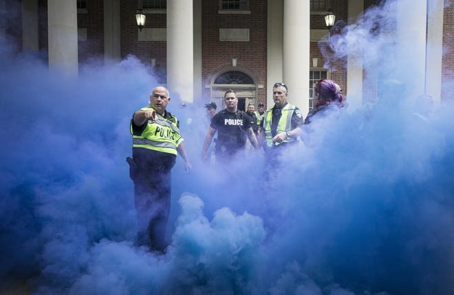 Police deploy smoke bombs into a crowd to disperse protesters after making arrests on the campus of the University of North Carolina campus in Chapel Hill, N.C. Supporters and opponents of the Silent Sam statue faced off again late Saturday afternoon on the UNC campus. [THE ASSOCIATED PRESS]
