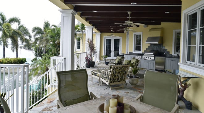 A view of the wide back porch, part of which is a convenient summer kitchen of a home on Putter Lane in the Country Club Shores neighborhood on Longboat Key. The pristine, four-bedroom, two-story home is on the market for $3,250,000. [Herald-Tribune staff photo / Thomas Bender]