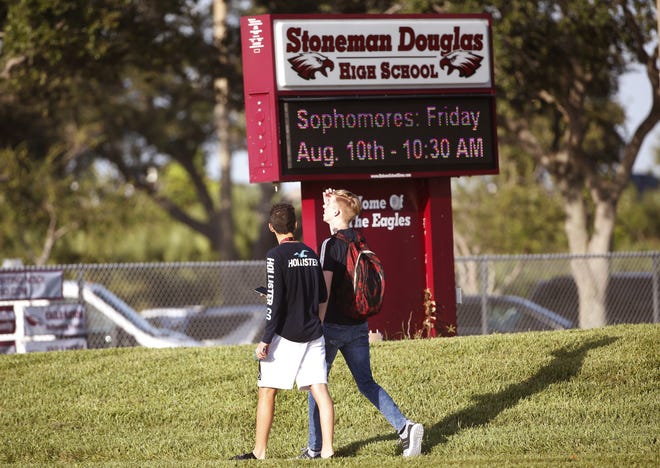 Students walk to class at Marjory Stoneman Douglas High School, in Parkland. Students at the school returned to a more secure campus as they began their first new school year since a gunman killed 17 people in the freshman building. (AP Photo/Wilfredo Lee)