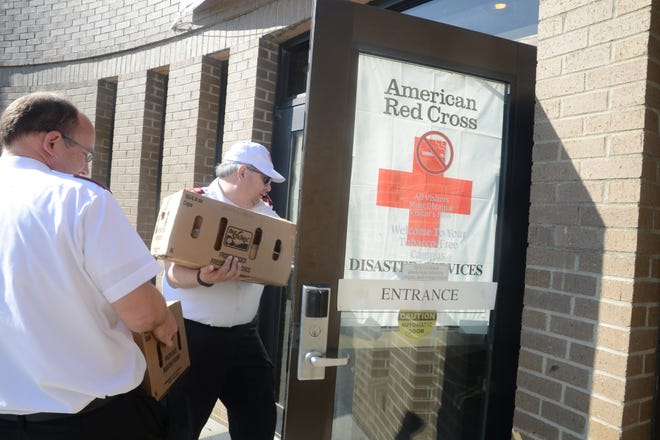 Salvation Army Cpt. Curtis Kratz and Maj. Hank Harwell carry supplies into the Red Cross shelter at Lenoir Community College in 2016. [File Photo, Janet S. Carter / The Free Press]