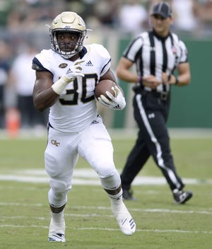 Georgia Tech running back KirVonte Benson (30) gains yards during the first quarter of an NCAA football game against South Florida, in Tampa, Fla. Benson will miss the rest of the season with a knee injury. [JASON BEHNKEN/THE ASSOCIATED PRESS]
