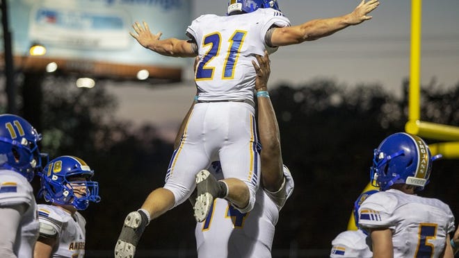 Anderson offensive lineman Jeremiah Byers lifts running back Coy Fullmer into the air after Fullmer scored a touchdown during the Trojans’ game versus McCallum in week one. Anderson faces Del Valle Thursday in the District 25-6A opener for both teams (Nick Wagner/American-Statesman)