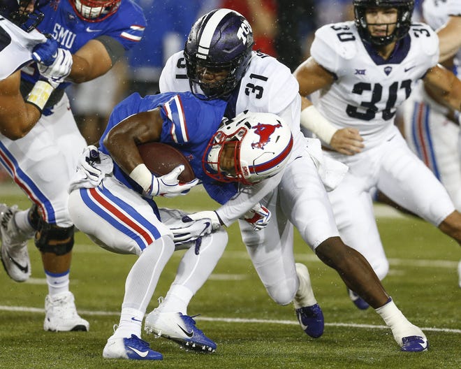 SMU running back Braeden West is tackled by TCU safety Ridwan Issahaku during the Horned Frogs' 42-12 win on Friday. The TCU defense gave up just 242 total yards. [Jim Cowsert/The Associated Press]
