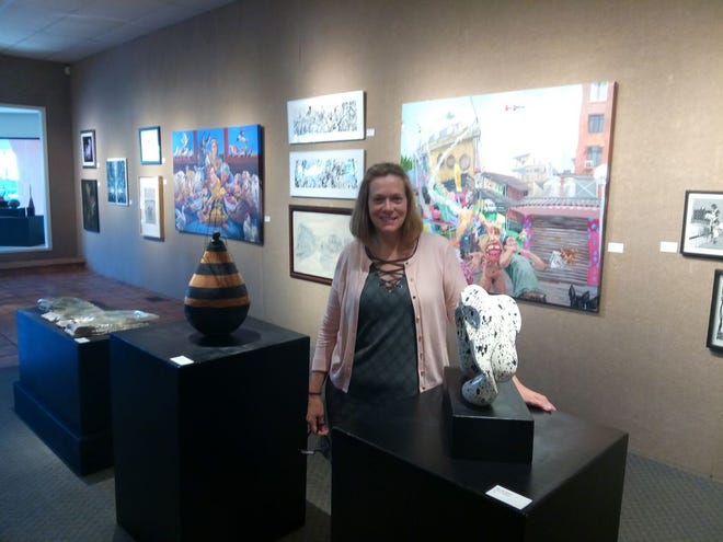 Buchanan Center for the Arts Executive Director Kristyne Gilbert poses among the exhibits at the National Juried Exhibition. The exhibit runs through Oct. 20 and is sponsored by Midwest Bank.