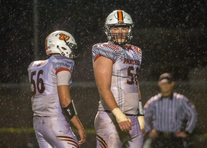 MATT DAYHOFF/JOURNAL STAR Washington teammates J.J. Guedet (50) and Will Crouch stand in the pouring rain during a break in the action against Limestone on Friday, Sept. 7, 2018 in Bartonville.