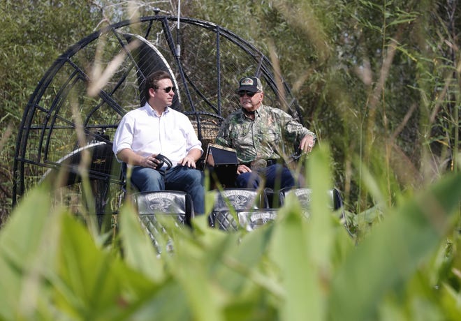 Republican candidate for Florida Governor Ron DeSantis, left, chats with Gladesman and former Florida Fish and Wildlife Conservation commissioner Ron Bergeron during an airboat tour of the Florida Everglades on Wednesday in Fort Lauderdale. [WILFREDO LEE/THE ASSOCIATED PRESS]
