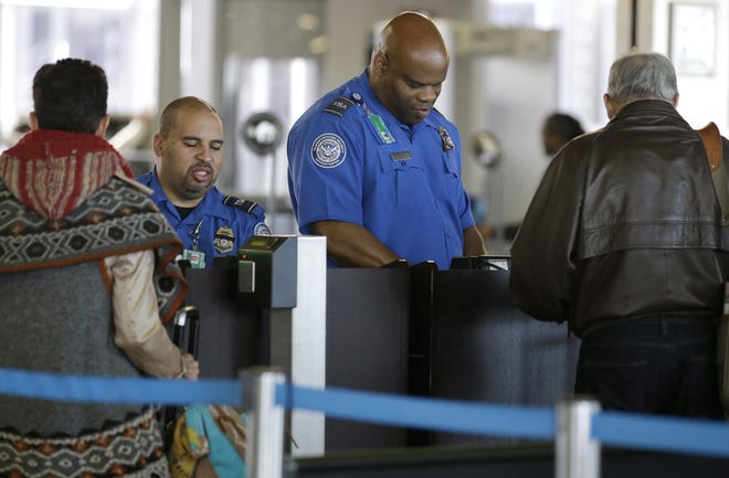 In this Nov. 25, 2015 file photo, Transportation Security Administration agents check travelers identifications at a security check point area in Terminal 3 at O'Hare International Airport in Chicago. (AP Photo/Nam Y. Huh, File)