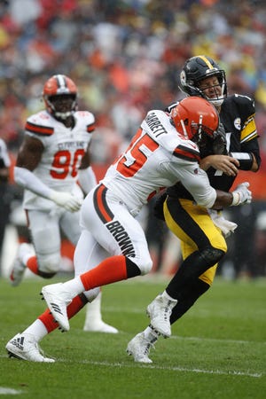 Browns defensive end Myles Garrett hits Pittsburgh Steelers quarterback Ben Roethlisberger during Sunday's game in Cleveland. The game ended in a 21-21 tie. [Jeff Haynes/AP Images for Panini]