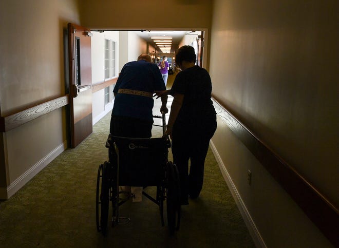 A nurse helps an elderly patient along the hall at the Trinity Grove nursing home in Wilmington, N.C., on Wednesday. MUST CREDIT: Washington Post photo by Ricky Carioti