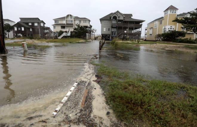 Ocean water breeches to the dunes in Avon, N.C., as the first effects of Hurricane Florence reach Hatteras Island on Thursday, Sept. 13, 2018.  (Steve Earley/The Virginian-Pilot via AP)