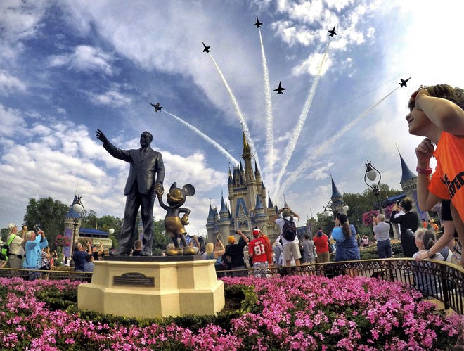 FILE- In this April 16, 2017 file photo, the Blue Angels, the U.S. Navy's legendary flight performance squadron, fly in formation over Cinderella Castle and the 'Partners' statue at the Magic Kingdom at Walt Disney World, in Bay Lake, Fla. Florida emergency officials said Thursday, Sept. 13, 2018, they had no way of tracking how many residents from the Carolinas had escaped to Florida this week. But some hotels were offering special discounts for evacuees and Florida ports were opening their terminals to cruise ships making unexpected ports of call.(Joe Burbank/Orlando Sentinel via AP, File)