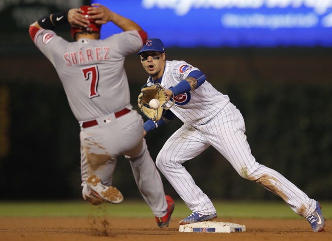 The Cincinnati Reds' Eugenio Suarez, left, is out at second base as the Chicago Cubs' Javier Baez tags the base during the sixth inning of Friday's game in Chicago. [AP Photo/Jim Young]