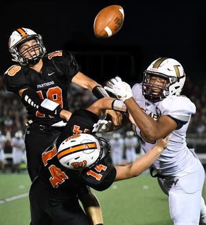 RON JOHNSON/JOURNAL STAR Washington's Cole Ludolph (18) and teammate Caleb Fisher (14) break up a pass intended for Dunlap wide receiver Josiah Miamen during Friday's Mid-Illini conference game.