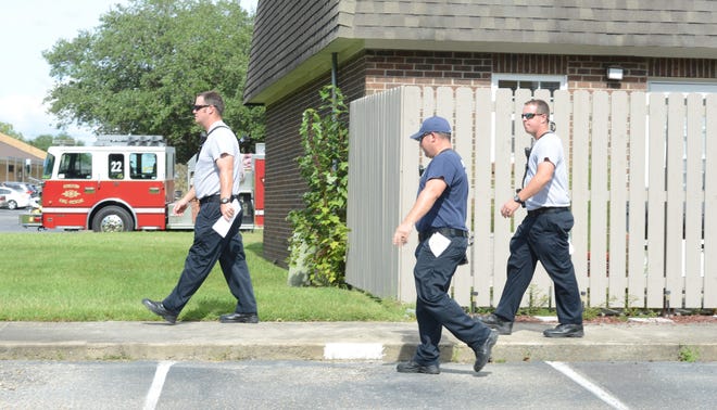Kinston Fire fighters go door-to-door to hand out flood warnings Wednesday at Herritage Court Apartments. [Janet S. Carter / The Free Press]