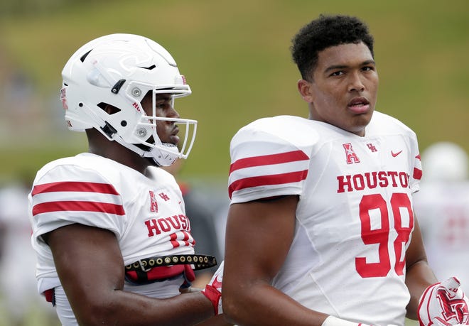 Houston Cougars defensive tackle Ed Oliver, left, helps Houston Cougars defensive lineman Payton Turner (98) with his pads during warm ups before the start of a Sept. 1 game against the Rice Owls in Houston. [AP Photo/Michael Wyke]