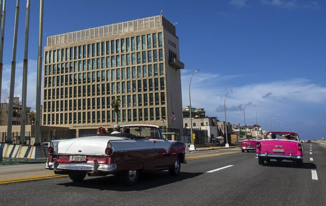 In this Oct. 3, 2017, file photo, tourists ride classic convertible cars on the Malecon beside the United States Embassy in Havana, Cuba. [ AP FILE PHOTO ]