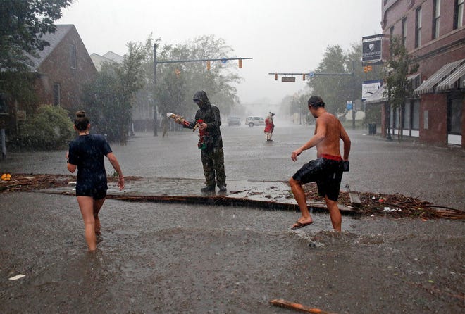 People survey the damage caused by Hurricane Florence on Front Street in downtown New Bern, N.C., on Friday, Sept. 14, 2018.
