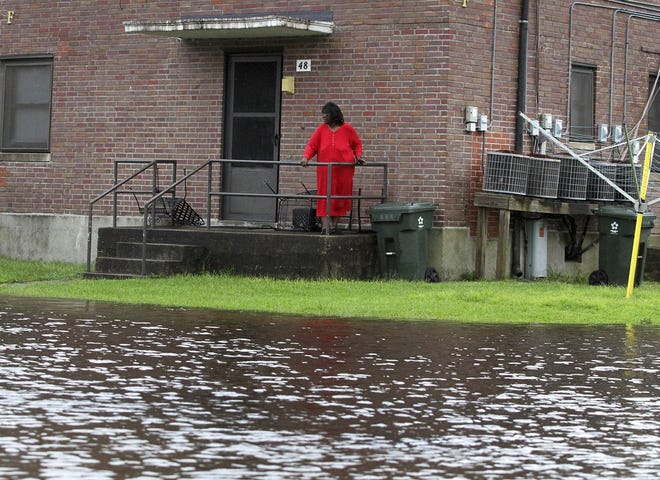 Residents at Trent Court Apartments wait out the weather as rising water gets closer to their doors in New Bern, N.C. Thursday, Sept. 13, 2018. Hurricane Florence already has inundated coastal streets with ocean water and left tens of thousands without power, and more is to come. [Gray Whitley/Sun Journal via AP]