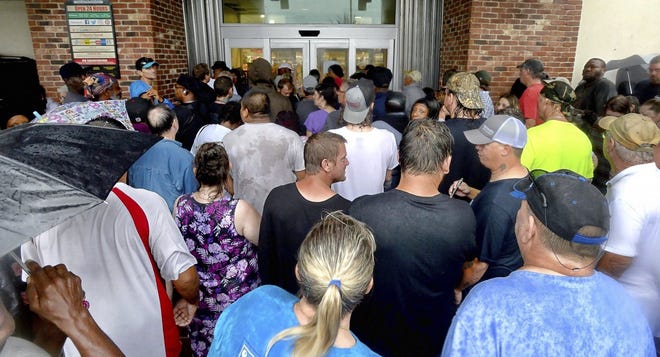 Hundreds line up as a Harris Teeter Supermarket opens its doors Saturday, Sept.15, 2018 following Florence, now a tropical storm, in Wilmington, N.C.  (Chuck Liddy/The News & Observer via AP)