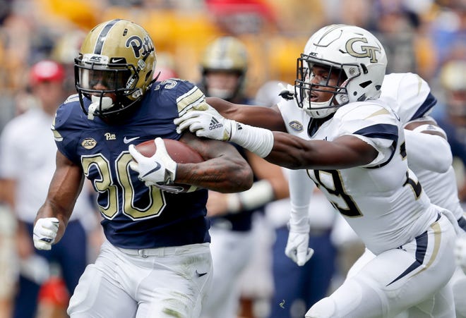 Pittsburgh running back Qadree Ollison (30) breaks free from Georgia Tech defensive back Tariq Carpenter on his way to a touchdown run in the first quarter Saturday in Pittsburgh. [KEITH SRAKOCIC/THE ASSOCIAATED PRESS]