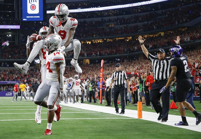 Ohio State wide receivers Binjimen Victor (9) and Terry McLaurin (83) pile on teammate K.J. Hill after Hill scored on a 24-yard reception to end a third-quarter scoring flurry for the Buckeyes. The touchdown and subsequent extra point gave OSU a 33-21 lead over TCU. [Joshua A. Bickel/Dispatch]
