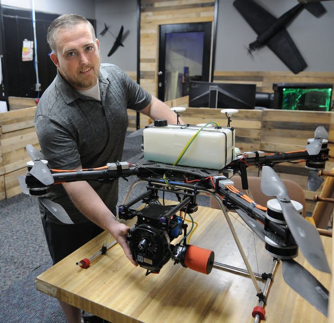 Ryan Zoller shows the gasoline- and battery-powered, long endurance, heavy payload multirotor drone that he and a team from his company, DV8 Tech, built and won a $50,000 prize. [TOM DORSEY / SALINA JOURNAL]