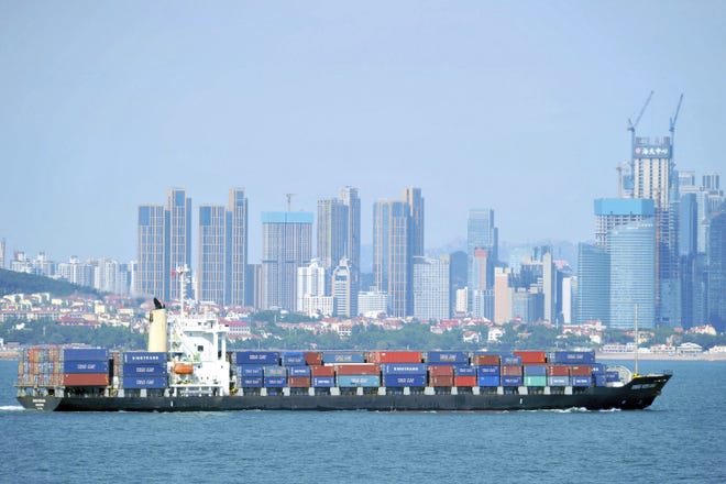 In this Sept. 13, 2018, photo, a container ship sails past the city skyline of Qingdao in eastern China's Shandong province. The Trump administration announced Monday, Sept. 17, 2018, that it will impose tariffs on $200 billion more in Chinese goods starting next week, escalating a trade war between the world's two biggest economies and potentially raising prices on goods ranging from handbags to bicycle tires. (Chinatopix via AP)