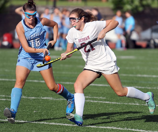 Dedham senior Bridgette Crowley, right, brings the ball up field with an air dribble against Medfield's Erin Seibel in Monday's 5-3 win . Wicked Local Staff Photo/Art Illman