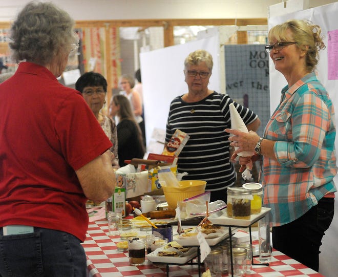 Cindy Becker, right, smiles as she talks about making mini pies to a group gathered in Mozelle Hall during Ladies' Day at the Ashland County Fair on Wednesday.