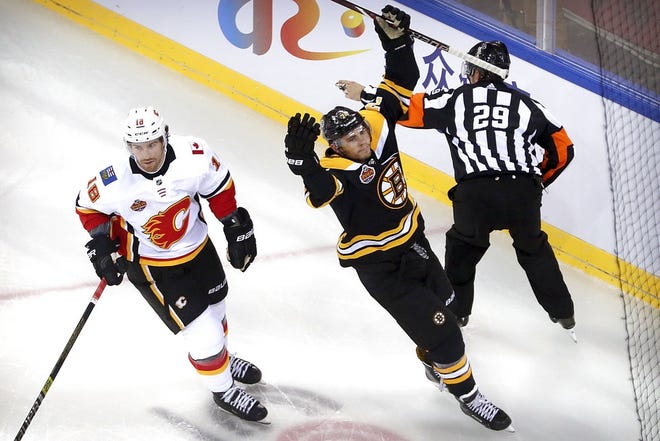 Jake DeBrusk, right, celebrates next to James Neal (18) of the Calgary Flames after scoring during the first period in Beijing, China, Wednesday. [AP Photo/Mark Schiefelbein]