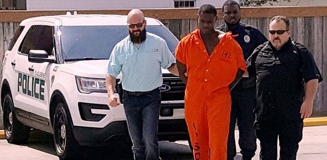 Det. Sgt. Chris Joffrion, murder suspect Darius Washington, Officer Demetre Jackson and Det. Sgt. John Little (left to right) are shown during Washington's walk on his way into the Plaquemine Police Department.