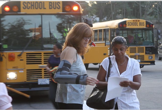 Joann Smith, left, the route foreman for bus monitors for the Providence School Department, talks with a bus monitor about her assignment on the first day of school in this 2010 file photo. [The Providence Journal file / Mary Murphy]